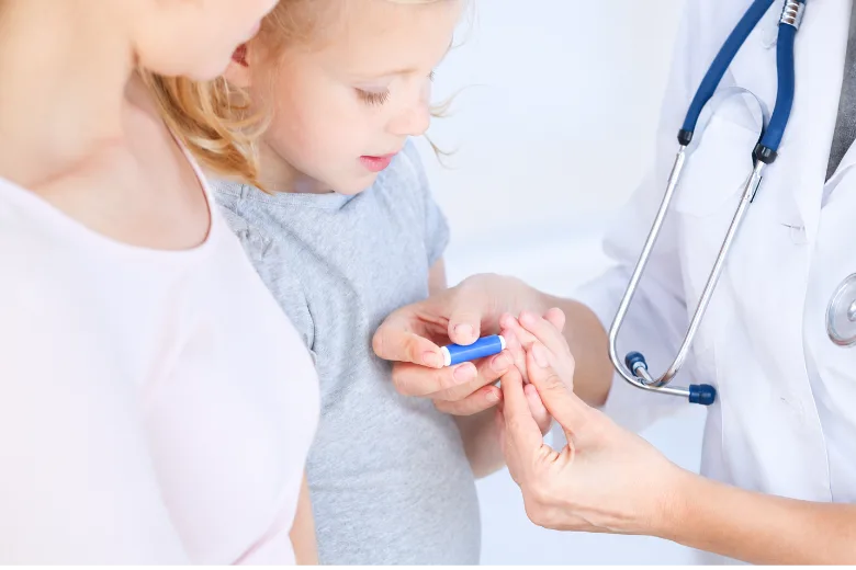 Kinderärztin nimmt einem Kind Blut aus der Fingerbeere ab