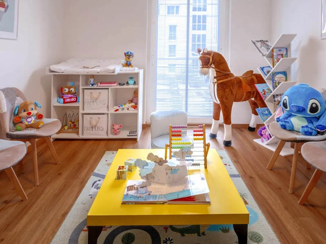 Spielecke im Wartebereich mit Kindertisch, Spielsachen und Bilderbüchern